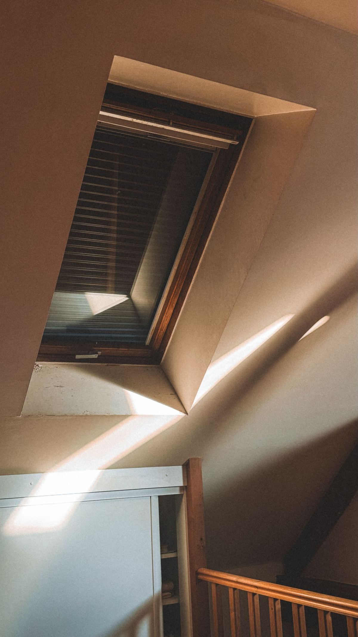 Fenêtre de toit ensoleillée dans un intérieur de combles en bois